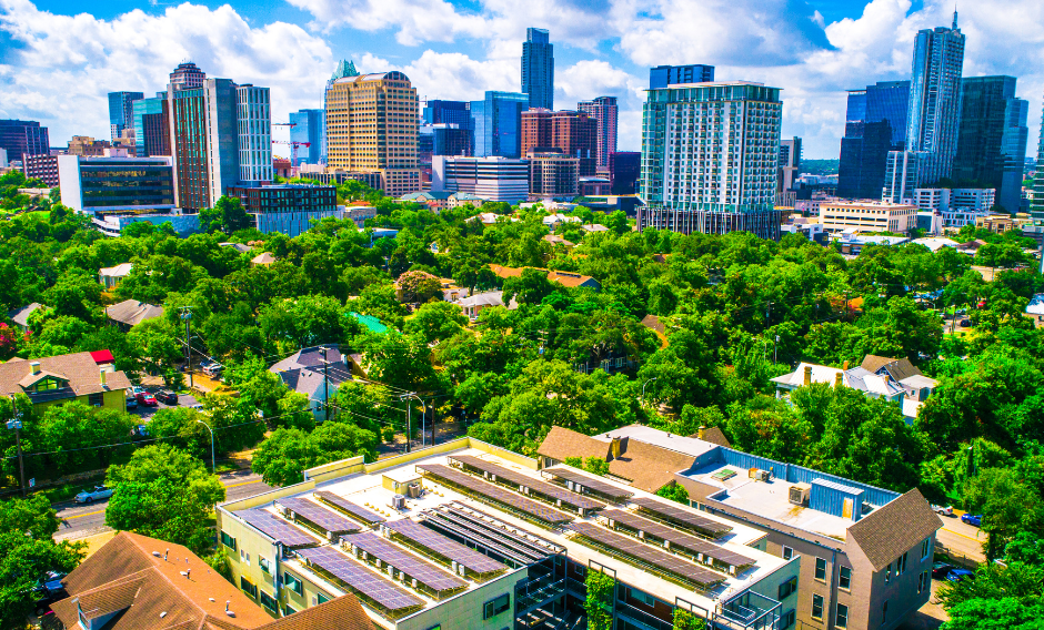 Solar panels on apartments with Austin skyline in background.